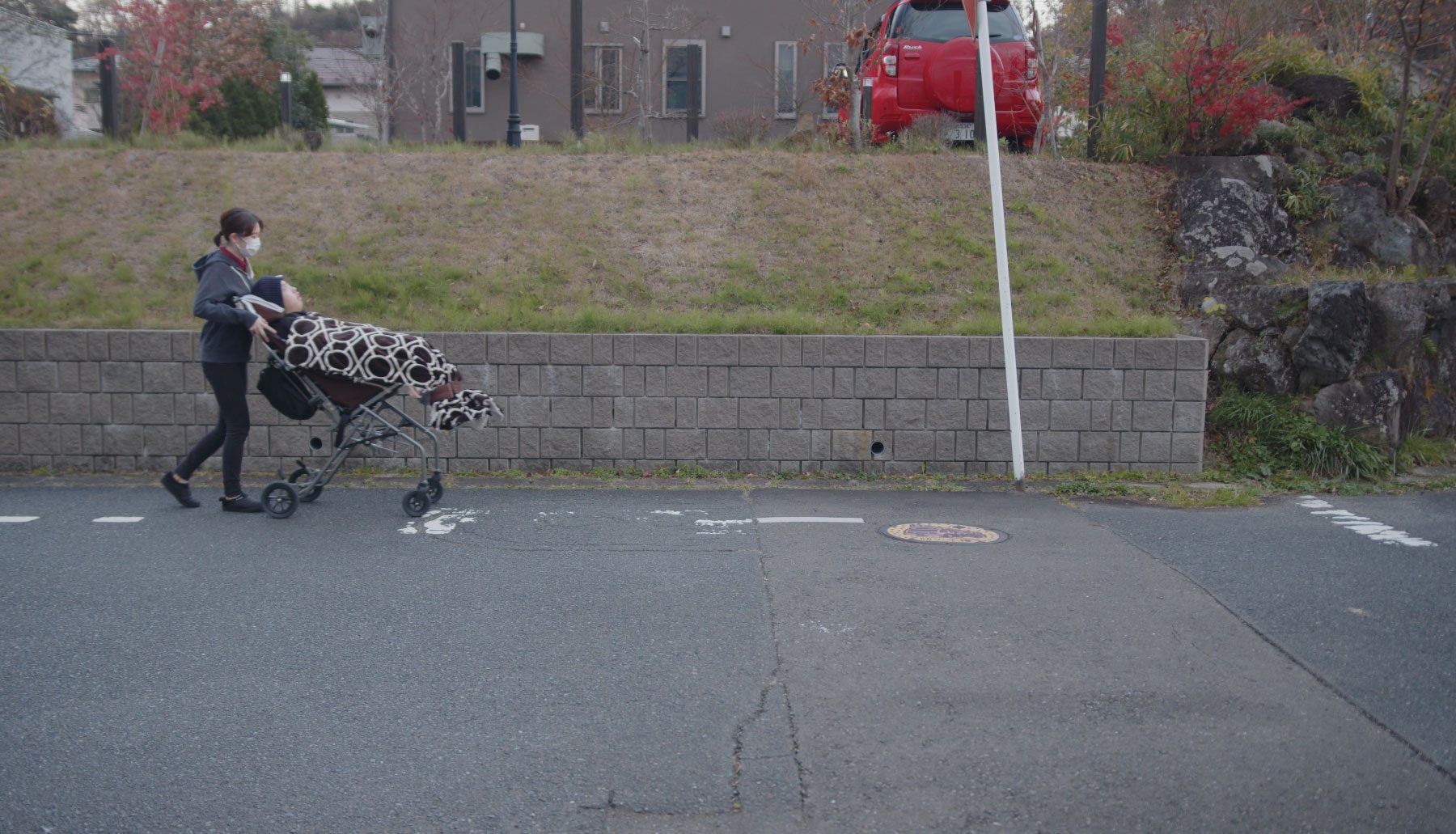 お母さんがバギーを押して歩道を歩いている様子